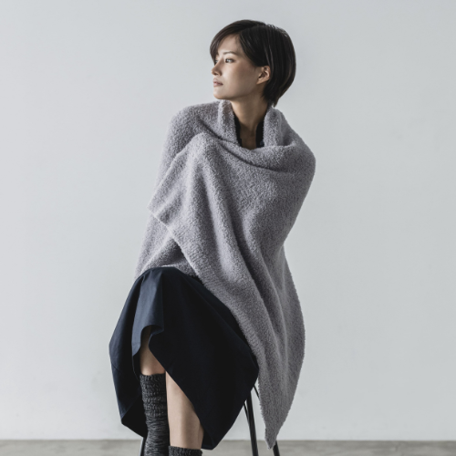 光電子®素材のプウアボーテ ブランケットを身体に纏っている女性